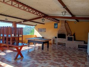 a room with a ping pong table and a fireplace at Chácara sol nascente in Suzano