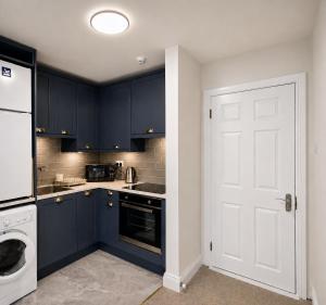 a kitchen with blue cabinets and a white door at Waterford Triangle Apartment in Waterford