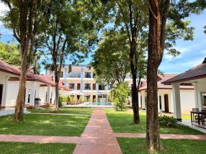 a walkway through the courtyard of a building with trees at Kep Queen Boutique in Phumĭ Ŏng Char