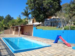 a pool with a slide and a playground at Chácara sol nascente in Suzano