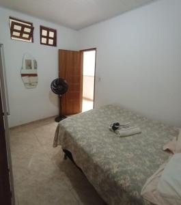 a bedroom with a bed with a phone on it at Aluguel de quarto com suite in Aracaju
