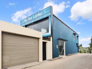 a blue building with a garage at Evolve SAYA in Talawatugoda