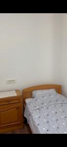 a bedroom with a bed and a wooden night stand at Miković Apartments in Herceg-Novi