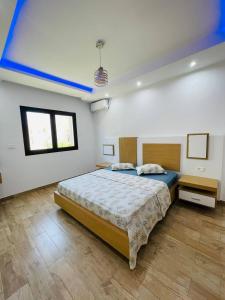 a bedroom with a bed with a blue ceiling at Résidence petit paris RDC2 in Kelibia