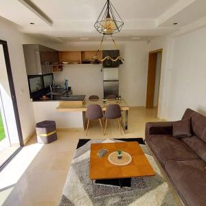 a living room with a couch and a table at Résidence petit paris RDC2 in Kelibia