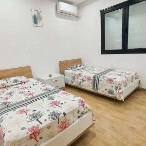 a bedroom with two beds and a window at Résidence petit paris RDC2 in Kelibia