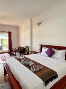 a bedroom with a large bed and a living room at Kep Queen Boutique in Phumĭ Ŏng Char