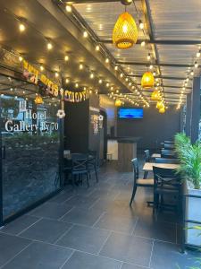 a dining room with tables and chairs and lights at Hotel Gallery By 70 in Medellín