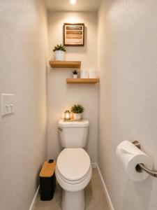 a bathroom with a toilet with two plants on the wall at Casa Blanca Luxury Spa Suite with fireplace, Disc Golf, 5 beds in Tulsa +29 photos