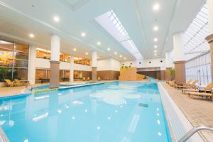 a large swimming pool in a large building at Laguna Garden Hotel in Ginowan