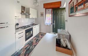 a kitchen with white cabinets and a green door at Cozy Home In Capaccio in Foce del Sele