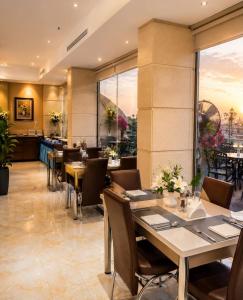 a restaurant with tables and chairs and a large window at Smart Gate Hotel Apartments سمارت غيت للشقق الفندقية in Jazan +29 photos