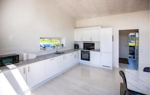 a white kitchen with white cabinets and a table at Gorgeous Home In Odder With Wifi in Odder