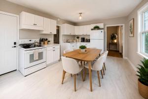 a kitchen with a wooden table and white appliances at Spacious 10BD Home, 12 min NYC & MetLife in Bayonne