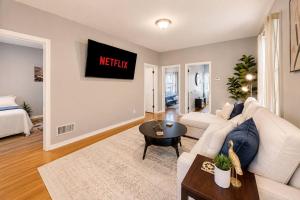 a living room with a white couch and a table at Spacious 10BD Home, 12 min NYC & MetLife in Bayonne