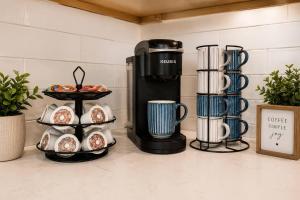 a coffee shop with a coffee maker and cups at Spacious 10BD Home, 12 min NYC & MetLife in Bayonne +14 photos
