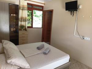 a bedroom with a bed with two pillows on it at Moorea Lodge Arii in Afareaitu