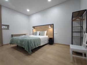 a bedroom with a large bed and a chair at Barcelos Habadia Adega in Lijó