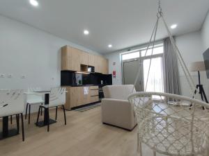 a living room with a table and chairs and a kitchen at Barcelos Habadia Adega in Lijó