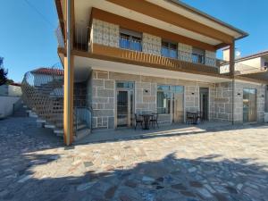 a building with a balcony with tables and chairs at Barcelos Habadia Adega in Lijó