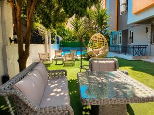 a patio with a table and chairs in a yard at Berm Suites in Antalya