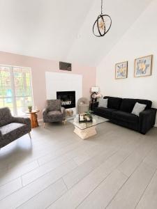 a living room with a black couch and chairs at Casa Blanca Luxury Spa Suite with fireplace, Disc Golf, 5 beds in Tulsa