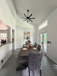 a dining room with a table and a ceiling fan at Casa Blanca Luxury Spa Suite with fireplace, Disc Golf, 5 beds in Tulsa