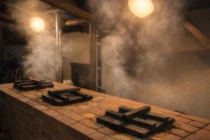 a brick counter with smoke in a room at 全5室の小さな温泉旅館 別府鉄輪温泉 萬力屋 in Beppu