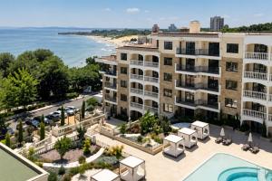 an aerial view of a building with a pool and a beach at Purple Rose Apartment Valencia Gardens in Nesebar