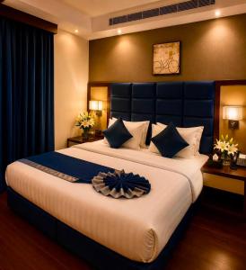 a bedroom with a large bed with a blue headboard at Smart Gate Hotel Apartments سمارت غيت للشقق الفندقية in Jazan