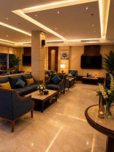 a living room with couches and a flat screen tv at Smart Gate Hotel Apartments سمارت غيت للشقق الفندقية in Jazan