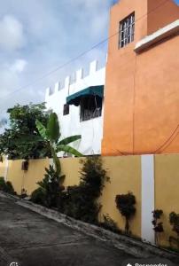 a building with a palm tree in front of it at Fantástico in Juan López +2 photos