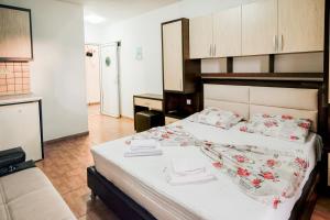 a bedroom with a large bed and a kitchen at Aparthotel Noldina in Donji Štoj
