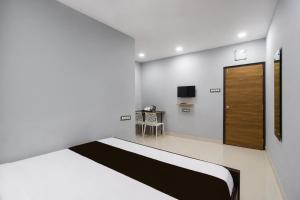 a white room with a bed and a tv at Hotel O OASIS Inn in Ibrāhīmpatan +23 photos
