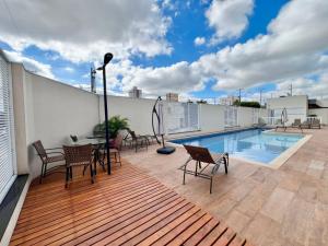 a patio with a table and chairs and a pool at Apartamento com vista Jd Higienopolis in Bauru