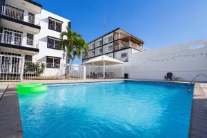 a swimming pool in front of a building at West Coast Apartments in Boqueron