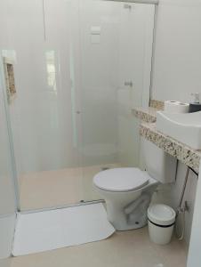 a bathroom with a shower and a toilet and a sink at Suíte Lençóis - Quarto amplo com Cozinha Integrada in Lençóis