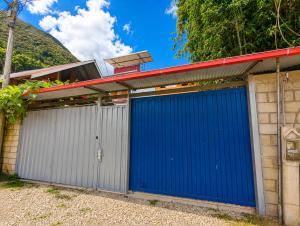 a pair of blue garage doors on a house at FRANKFURTER HOF FAMILIAR Oxapampa in Oxapampa +84 photos
