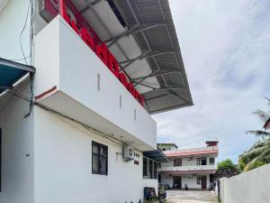 a white building with a red sign on the side at RedDoorz @ Malalayang Manado in Manado +18 photos