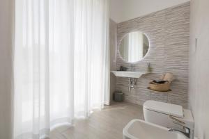 a bathroom with a toilet and a sink and a mirror at Dimore Margherita in Petacciato