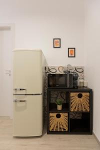 a white refrigerator in a kitchen with a microwave at Dimore Margherita in Petacciato +43 photos