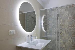 a bathroom with a sink and a mirror at Dimore Margherita in Petacciato