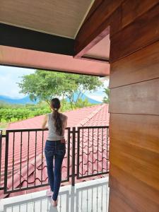 a woman standing on the balcony of a house at Divina Naturaleza in Agua Azul