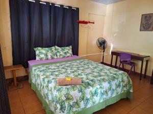a bedroom with a bed with a black curtain and a table at Haekua Chez Mel in Nuku Hiva +37 photos