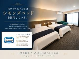 two beds in a hotel room with writing on the wall at Hotel 21 in Kusatsu