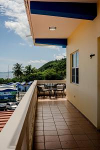 a balcony with tables and chairs and a view of the water at Sueños del Mar in Fajardo