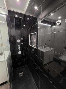 a black bathroom with a shower and a sink at Apartamento para 6 hóspedes em Queluz próximo Lisboa,Sintra e Cascais in Queluz +53 photos
