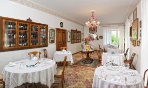 a dining room with white tables and chairs and a chandelier at Romantic Hotel & Restaurant Villa Cheta Elite in Maratea