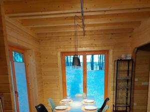 a dining room with a table in a wooden house at Forest park at Roofensee in Stechlin