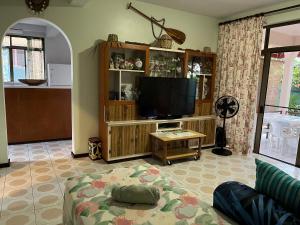 a living room with a tv and a couch at Belle Maison F3 in Papeete